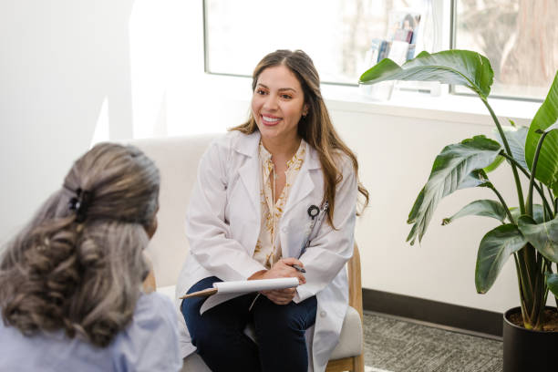 istock Female social worker smiles while speaking with the unrecognizeable patient 1487357439