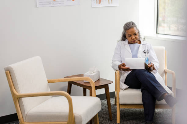 istock Mature female doctor writes down a treatment plan for her patient 1487357471