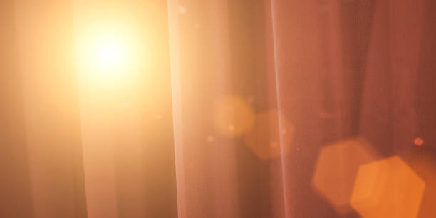 istock Bright sunlight shines through transparent curtain on window at dawn. 1487357644