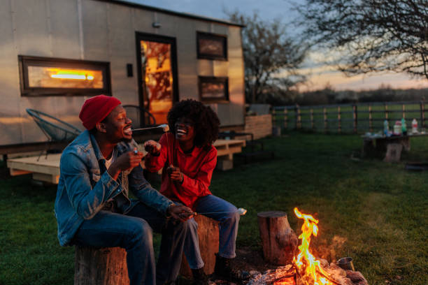 istock Fashionable couple sitting at campfire. 1487359369