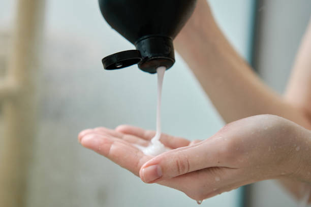 istock Woman pouring shampoo on hand in bathroom 1487360679