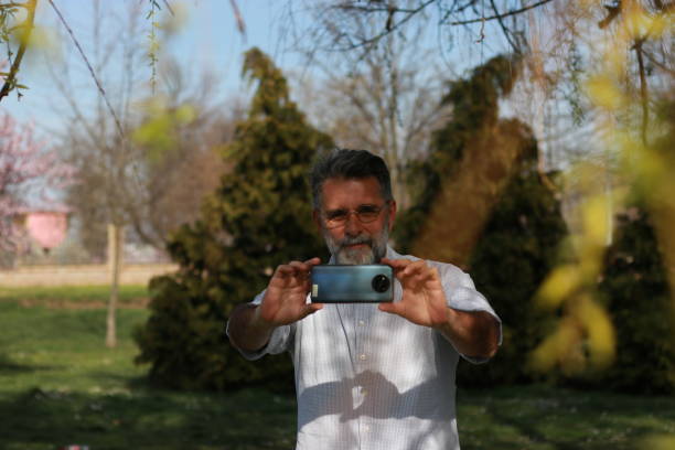 istock Senior man in nature using phone 1487360929