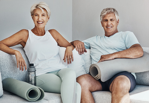 Fitness, yoga and portrait of senior couple on sofa smile ready for wellness, healthy body and workout. Sports, retirement and happy elderly people with gym mat for exercise, training and pilates