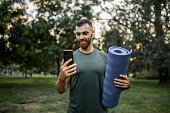  Sporty young man using phone and preparing for workout