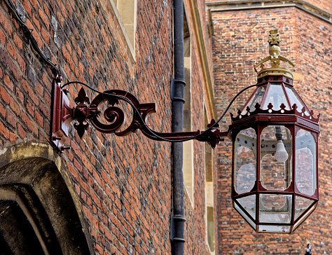Old lamps hanging on the brick wall at Hampton Court Palace, a royal palace in the London Borough of Richmond upon Thames, United Kingdom. 22nd of April 2023