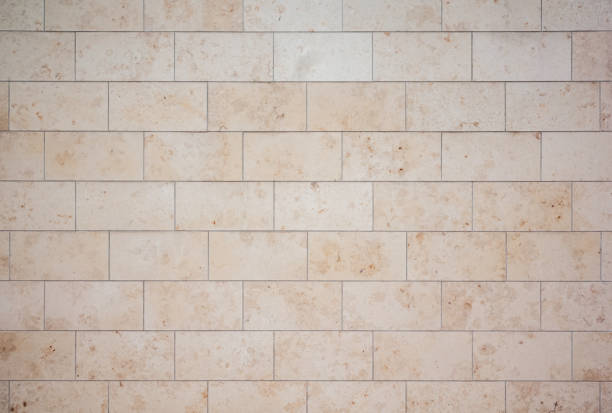istock texture of a tiled beige stone wall as background, natural stone wall texture as background. 1487365921