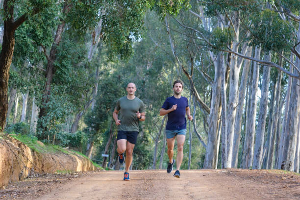 istock Two runners running together on a gravel road in a eucalyptus forest 1487365934
