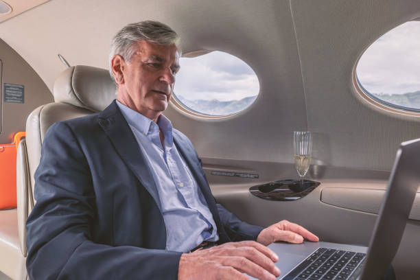 istock Senior business man working on laptop in a private jet 1487366204