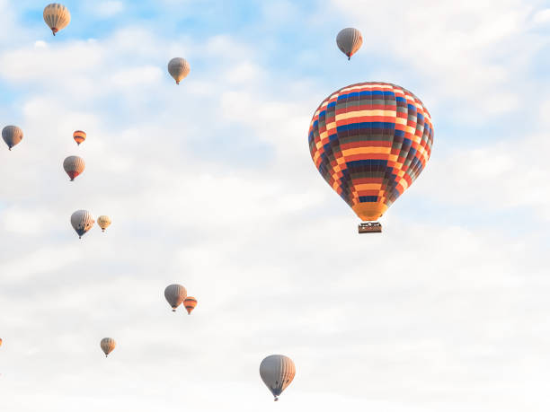 日の出、夜明けの早い山のカッパドキアで空に多くの明るい色の美しい風船を飛ばします。バーナーからの熱風でバルーンを満たし、大きなバスケット。観光ツアー、クラウドフライト - turkey hot air balloon cappadocia basket ストックフォトと画像