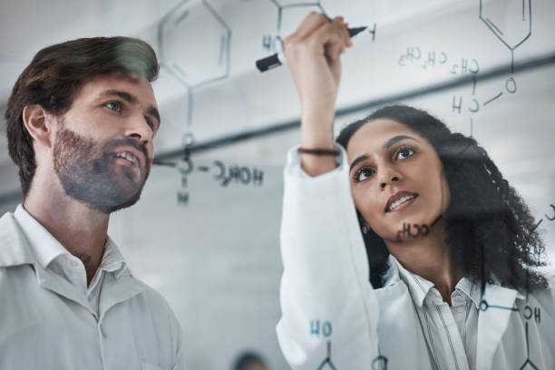 istock Teamwork, science and chemistry with people writing in laboratory for medicine, pharmacy or healthcare. Research, analytics and medical with scientists solving on glass board for idea, study or data 1487366270