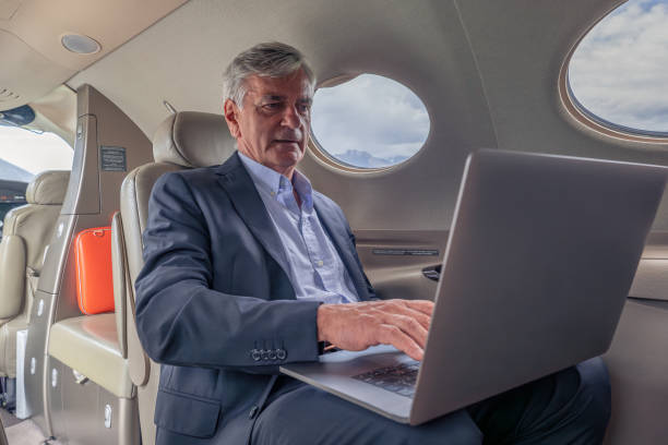 istock Senior business man working on laptop in a private jet 1487366314