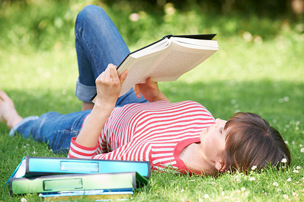 istock Female Student Reading Textbook In Park 148737182