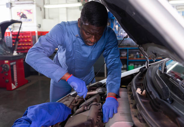 istock Professional american mechanic man in uniform repairing car engine 1487380608