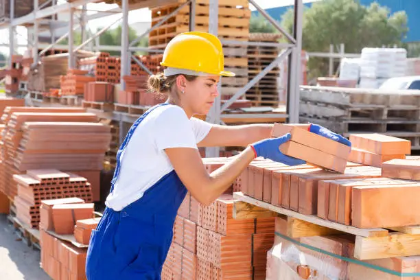 Photo of Female worker with bricks in warehouse