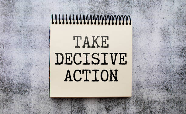 istock On the table are reports, pencils and a notebook with the inscription - TAKE DECISIVE ACTION. 1487380690