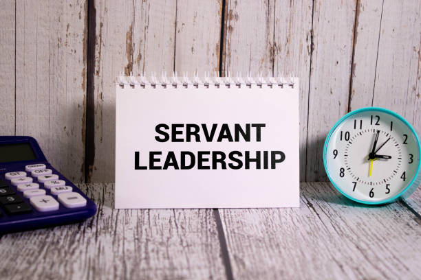 istock Servant Leadership write on paperwork isolated on Wooden Table. 1487380691