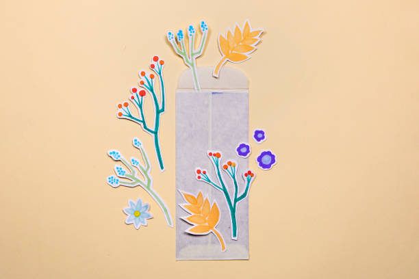 istock Envelope with paper flowers deco arrangement on yellow background. Greetings concept, invitation, wedding birthday card. 1487381833