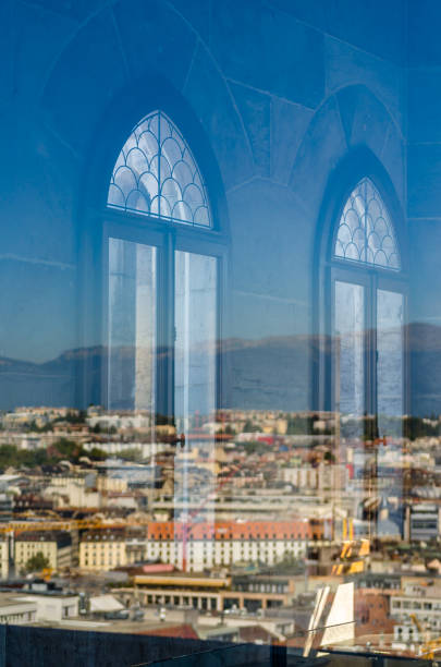 This image shows a stunning Gothic window featuring intricate tracery and clear leaded glass panes, framed by Gothic pointed arches. Through the glass, lush green trees and a soft blue light can be seen, creating a serene and mystical atmosphere. The window's structure emphasizes the vertical elegance characteristic of Gothic architecture. XXL image, isolated on white, clipping path.