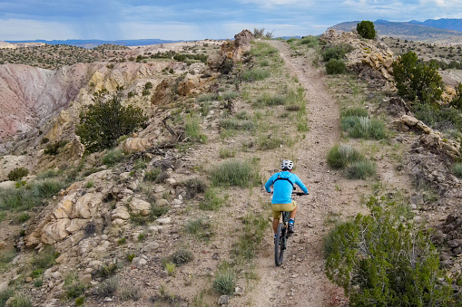 nice, active senior woman riding her electric mountain bike in the pine tree forests near Granada, Andalusia, Spain