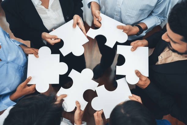 istock Diverse corporate officer workers connecting puzzle pieces. Concord 1487385382