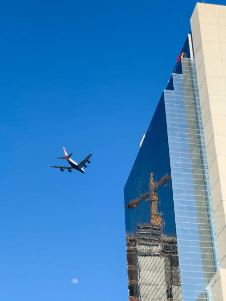 istock Plane flying over a glass building 1487386313