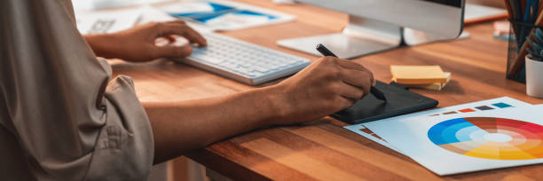 istock Graphic designer works on computer laptop with digital pen. Scrutinize 1487387399