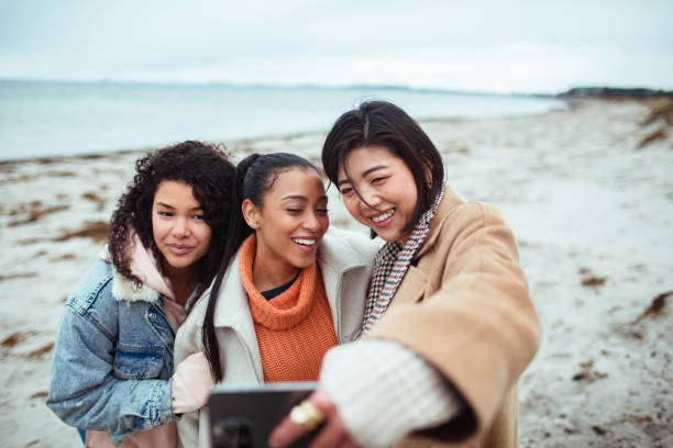 istock Three young women taking a selfie on a beach 1487388396