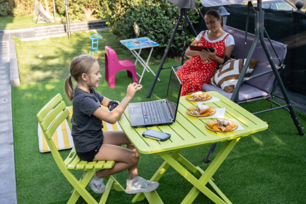 istock Pregnant mom helps daughter with homework in the backyard. 1487393205