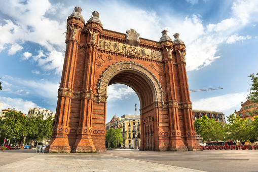 People walk by the Arch of Triumph in the district of downtown Promenade Passeig de Lluís Companys.  In 1888 Barcelona hosted the Universal Exhibition. The Arc de Triomf was built as the gateway to the fair which was held in the Parc de la Ciutadella.