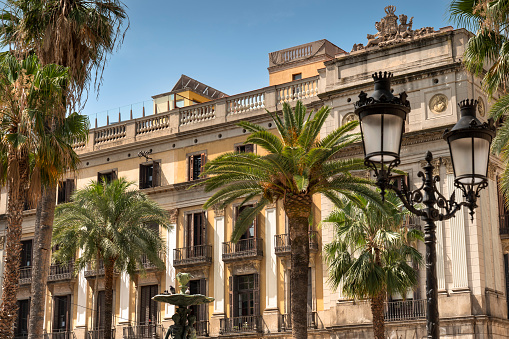 Architectural building detail in Plaça Reial or Royal Plaza which is a public square with an ornate fountain and palm trees off of La Rambla in Barcelona Catalonia Spain