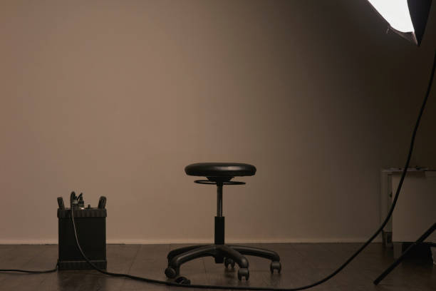 Empty studio, setup and chair for a photoshoot, film idea or art with a backdrop. Design, decoration and decor, lighting and equipment for shooting, artistic creativity and filming with a background