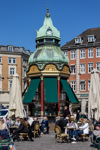 Copenhagen, Denmark April 8, 2023 People at a  classic cafe and kiosk with a copper roof on Kongens Nytorv in the springtime.