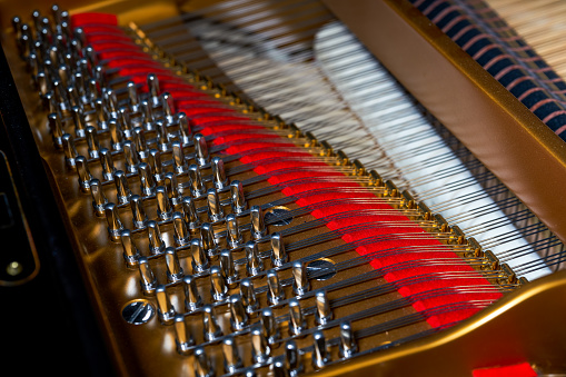 A close-up of the internal string structure of a top grand piano