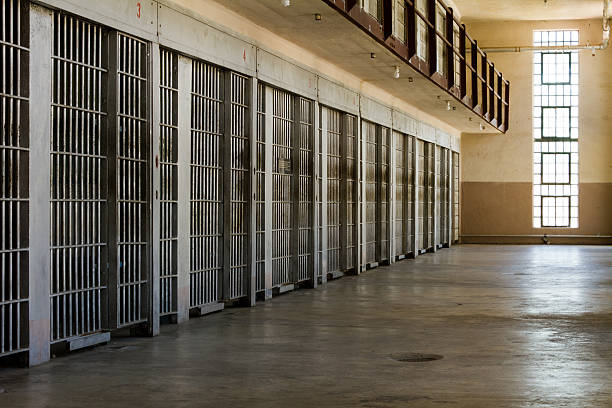 Jail cells lined up against the wall stock photo