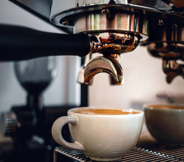 istock Espresso coffee extraction from a professional coffee machine with a bottomless filter, Close-up of a coffee drop  from the coffee machine 1487410604