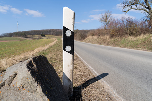 Reflector post at the edge of a german country road in springtime