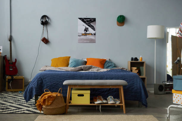 istock Front view of comfortable double bed with cushions standing by grey wall 1487419564