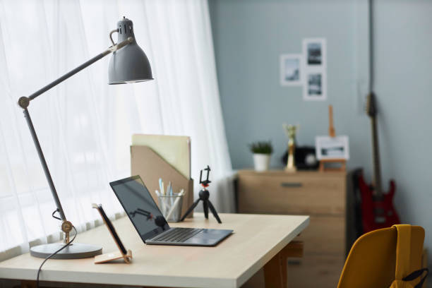istock Lamp on desk with laptop which is workplace of student or freelancer 1487419566