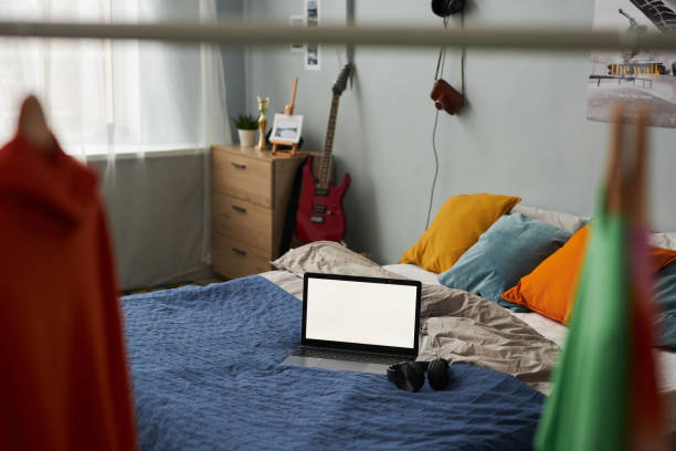 istock Laptop with blank screen standing on double bed with cushions 1487419577