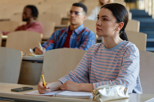 istock Young woman sitting at desk at lecture 1487422439