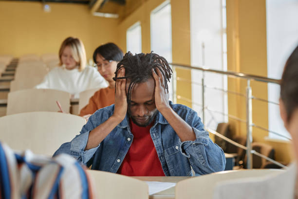 istock Schoolboy sitting at desk at exam 1487422592