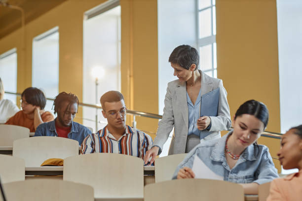 istock Teacher giving hints to students at exam 1487422649
