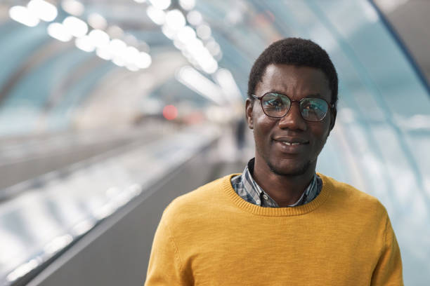African American man standing on escalator