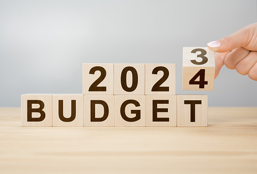 Business concept of planning 2024. Businessman flips wooden cube and changes words BUDGET 2023 to BUDGET 2024. New year business plan concept in 2024. Economy and business. Phrase 2024 BUDGET