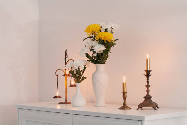 istock chrysanthemums flowers in vases and burning candles on white interior 1487428443