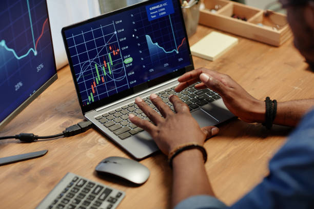 istock Hands of young African American broker analyzing financial graph 1487428685