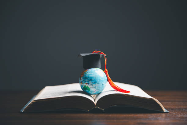 istock Graduate Studies or Studying KnowledgeLearn Abroad Concept Graduate Open Textbook with Maps Simulating. 1487430006