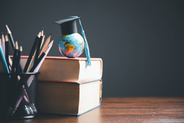 istock Graduate Studies or Studying KnowledgeLearn Abroad Concept Graduate Open Textbook with Maps Simulating. 1487430008