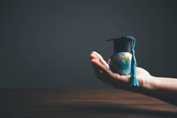 istock Graduate Studies or Studying KnowledgeLearn Abroad Concept Graduate Open Textbook with Maps Simulating. 1487430030