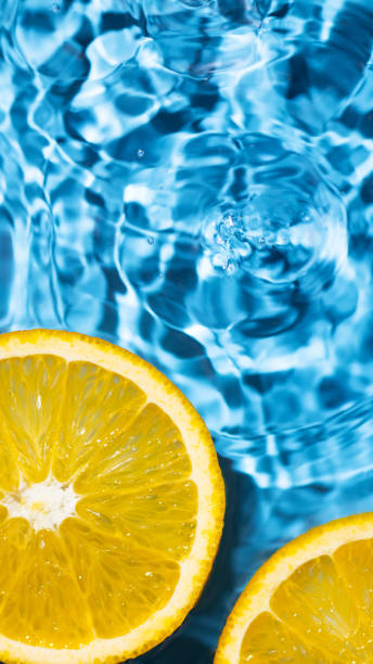 istock Creative summer background with orange fruit slices in swimming pool water. 1487433133